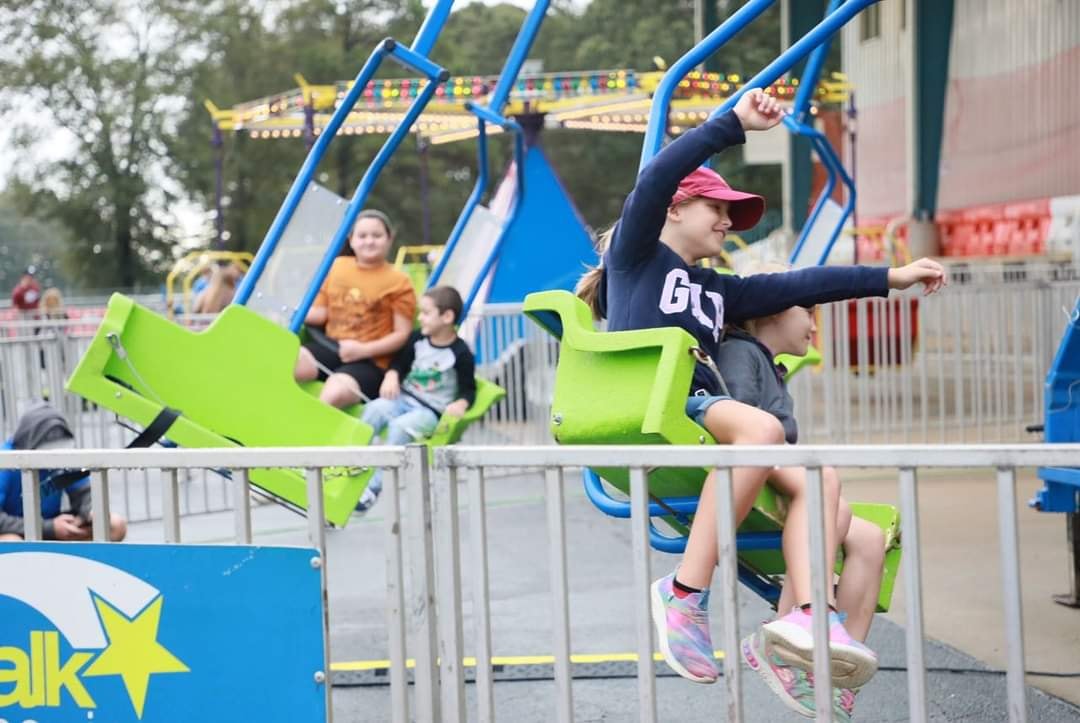 Girl with arms out on a swing ride